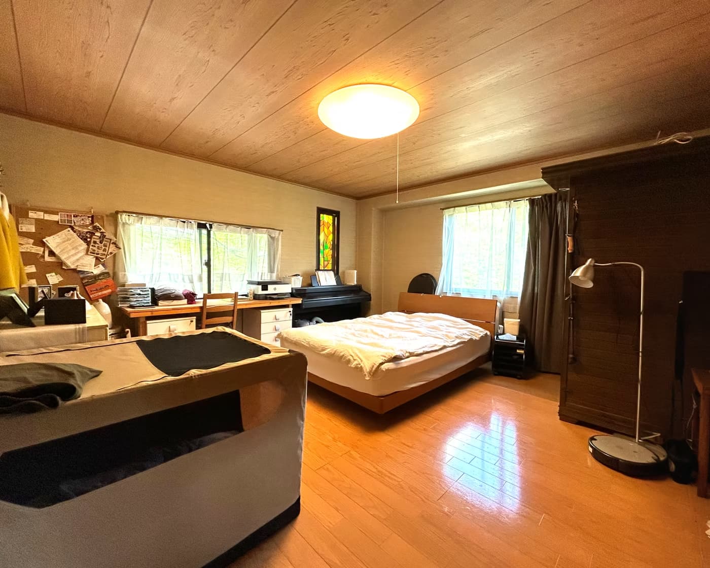 Large master bedroom with twin windows and desk